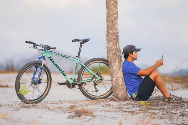 Boldog Kerékpáros Pihenés Egy Mountain Bike Parkolt Egy Fának Road — Stock Fotó