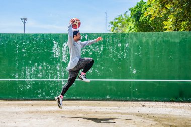 26 Haziran 2021 'de COVID-19 krizi sırasında dışarıda basketbol oynayarak egzersiz yapan adam, Surat Thani, Tayland.