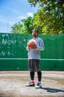 26 Haziran 2021 'de COVID-19 krizi sırasında dışarıda basketbol oynayarak egzersiz yapan adam, Surat Thani, Tayland.