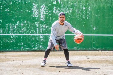 26 Haziran 2021 'de COVID-19 krizi sırasında dışarıda basketbol oynayarak egzersiz yapan adam, Surat Thani, Tayland.