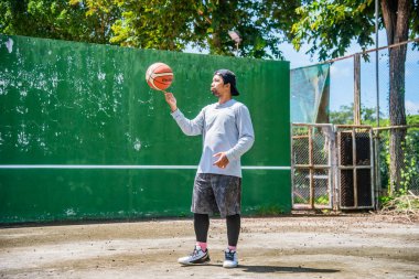 26 Haziran 2021 'de COVID-19 krizi sırasında dışarıda basketbol oynayarak egzersiz yapan adam, Surat Thani, Tayland.