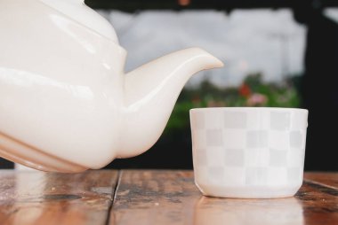 Beyaz fincana sıcak çay dök. covid-19 'a karşı sağlık için