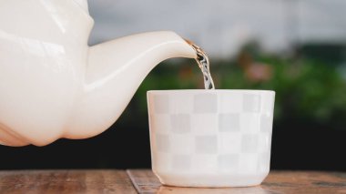 Beyaz fincana sıcak çay dök. covid-19 'a karşı sağlık için