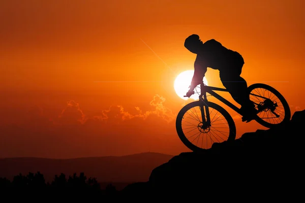 Silhouette of mountain bikers. Adventure. Mountain bikers going downhill.