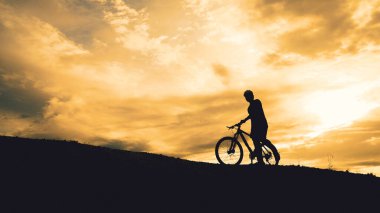 Turne bisikletçilerinin gölgeleri akşamları dağlarda güzel manzaralar sunuyor.