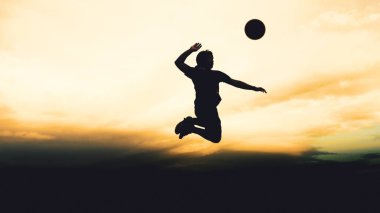 Bir voleybol oyuncusunun silueti dağda pratik yapıyor ve akşam çok güzel bir manzara sunuyor.