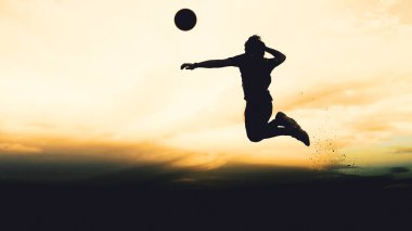 Bir voleybol oyuncusunun silueti dağda pratik yapıyor ve akşam çok güzel bir manzara sunuyor.