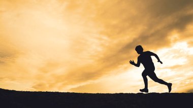 Akşamları güzel manzaralı dağlarda antrenman yapan koşucuların silueti.