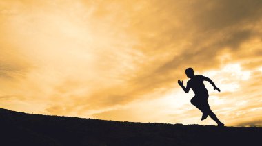 Akşamları güzel manzaralı dağlarda antrenman yapan koşucuların silueti.