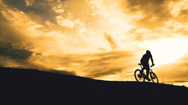 在山上练习的骑车人的轮廓 在晚上可以看到美丽的风景 — 图库照片