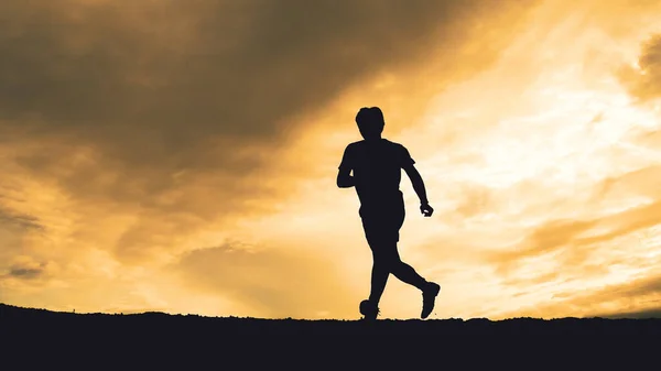 Silhouette of runners training in the mountains with beautiful views in the evening