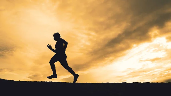 Silhouette of runners training in the mountains with beautiful views in the evening