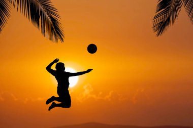 Bir plaj voleybolcusunun silueti atlayıp voleybol topuna vuruyor..