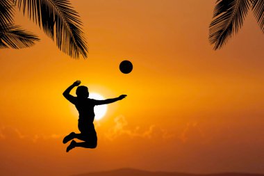 Bir plaj voleybolcusunun silueti atlayıp voleybol topuna vuruyor..
