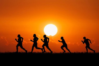 Akşamları güzel manzaralı dağlarda antrenman yapan koşucuların silueti. Bir grup koşucu akşamları dışarıda koşuyor. Spor antrenmanı konsepti