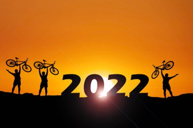 Akşamları bisikletle gezen üç adamın siluetleri. konsept mutlu yıllar 2022