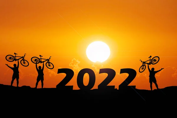 Вечером Силуэты Троих Мужчин Счастливо Поднимают Велосипеды Концепция Новым 2022 — стоковое фото