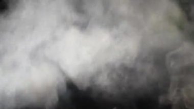 Beyaz Buhar Pan 'ın üstüne çıkıyor. Beyaz Buhar perde arkasındaki büyük bir çömlekten yükseliyor. Siyah arkaplan. 