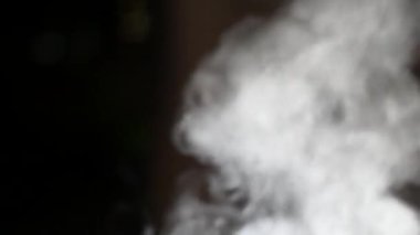 Beyaz Buhar Pan 'ın üstüne çıkıyor. Beyaz Buhar perde arkasındaki büyük bir çömlekten yükseliyor. Siyah arkaplan. 