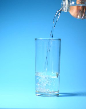 Mavi arka planda bardakta temiz içme suyu. sağlıklı içme suyu kavramı