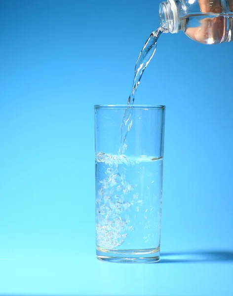 蓝色底色的杯子里有干净的饮用水 健康饮水概念 — 图库照片