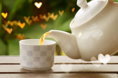  Cam çaydanlıktan küçük fincana kadar Çin çayını dolduran el. Bir kadının çay koyarkenar manzarası. Çay molası zamanı.. 