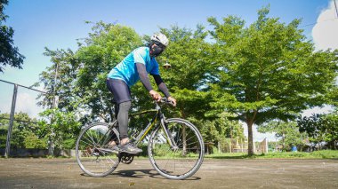 Erkekler işe gidip gelmek ya da egzersiz yapmak için bisiklet kullanırlar. 23 Ağustos 2021, Surat Thani, Tayland.