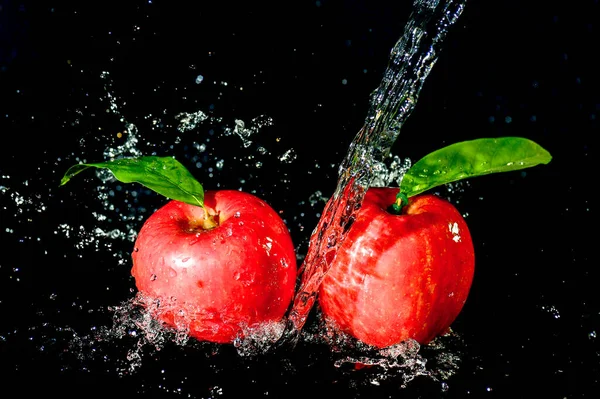 黒い背景に水の中の赤いリンゴが飛び散った 黒の背景にアップルウォータースプラッシュ — ストック写真