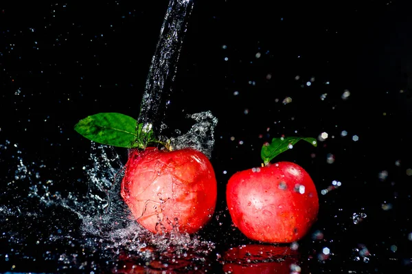 Red apples in water splash over black background. Apple water splash on black background