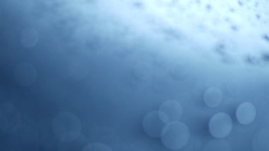 Mavi bokeh parçacıkları, toz gradyan soyut arkaplanı ödüllendirir. Mavi arkaplanda uzayda fütürist ışıltı. 