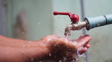 Musluktan su damlacıkları sızıyor, su tasarrufu kavramı.