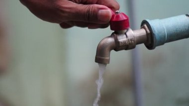 Musluktan sızan su damlacıkları, su tasarrufu kavramı.