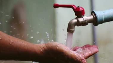 Musluktan sızan su damlacıkları, su tasarrufu kavramı.