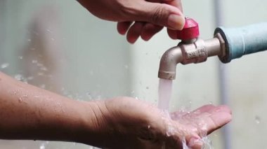 Musluktan sızan su damlacıkları, su tasarrufu kavramı.