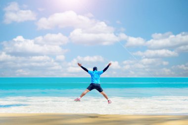 Sahilde koşan bir adam çok güzel bir deniz manzarası var. Sahilde koşuyor.