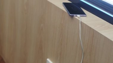 close up of phone and usb cable on a wooden table