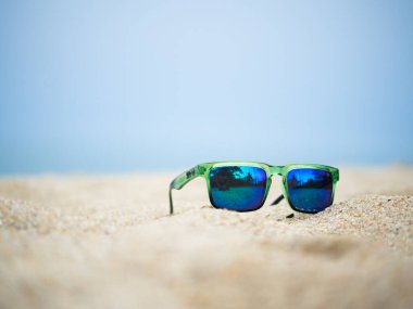 Sahilde uzanan güneş gözlüğünü kapat.