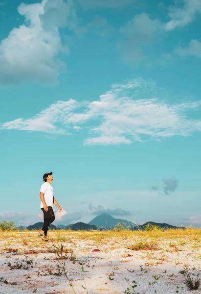 Asian man walking in sand on a nice day. Exercise and relaxation concepts