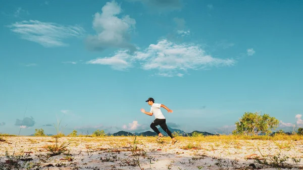 Asian man walking in sand on a nice day. Exercise and relaxation concepts