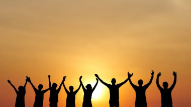 Gün batımında sahilde insan siluetleri..