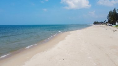 Sakin dalgaları ve açık mavi gökyüzü olan huzurlu kumlu sahil, dinlenmek ve yaz tatilleri için mükemmel..