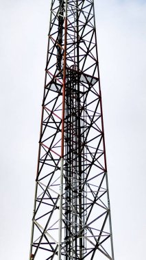 Bulutlu gökyüzüne uzanan, modern mühendislik ve endüstriyel tasarımı vurgulayan yüksek bir iletişim yapısı..