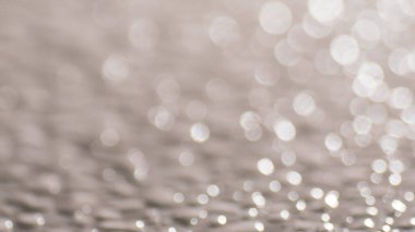 Yumuşak odaklı arka plan, nötr tonlarda parıldayan ışık çemberleriyle, rüya gibi ve ruhani bir atmosfer yaratıyor..