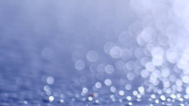 Işıldayan ışık yansımaları ile soyut mavi bokeh arkaplan, yaratıcı tasarım projeleri için mükemmel.