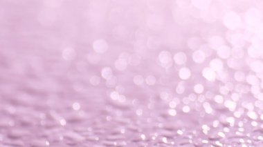 Pembe bokeh ve su damlacıklarının yer aldığı soyut resim, arkaplan ve tasarım projeleri için mükemmel.