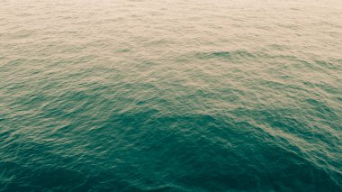 Yumuşak ışık altında sakin okyanus dalgaları, sakin ve huzurlu bir deniz manzarası yaratır..