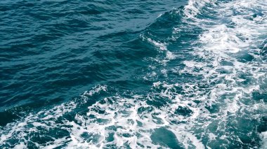 Beyaz köpüklü canlı okyanus dalgaları, denizin dinamik hareketini ve doğal güzelliğini gösteriyor..
