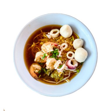 Beyaz bir kasede taze otlarla süslenmiş karides, mürekkep balığı ve balık köftesi içeren lezzetli bir Asya erişte çorbası..