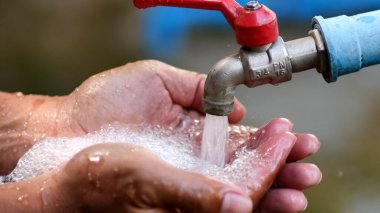 Musluğun altında sabun köpükleriyle yıkanan el temizliği ve temizliği vurgulayan yakın plan..