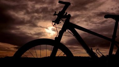 Siyah arka planı olan bir bisikletin silüeti.